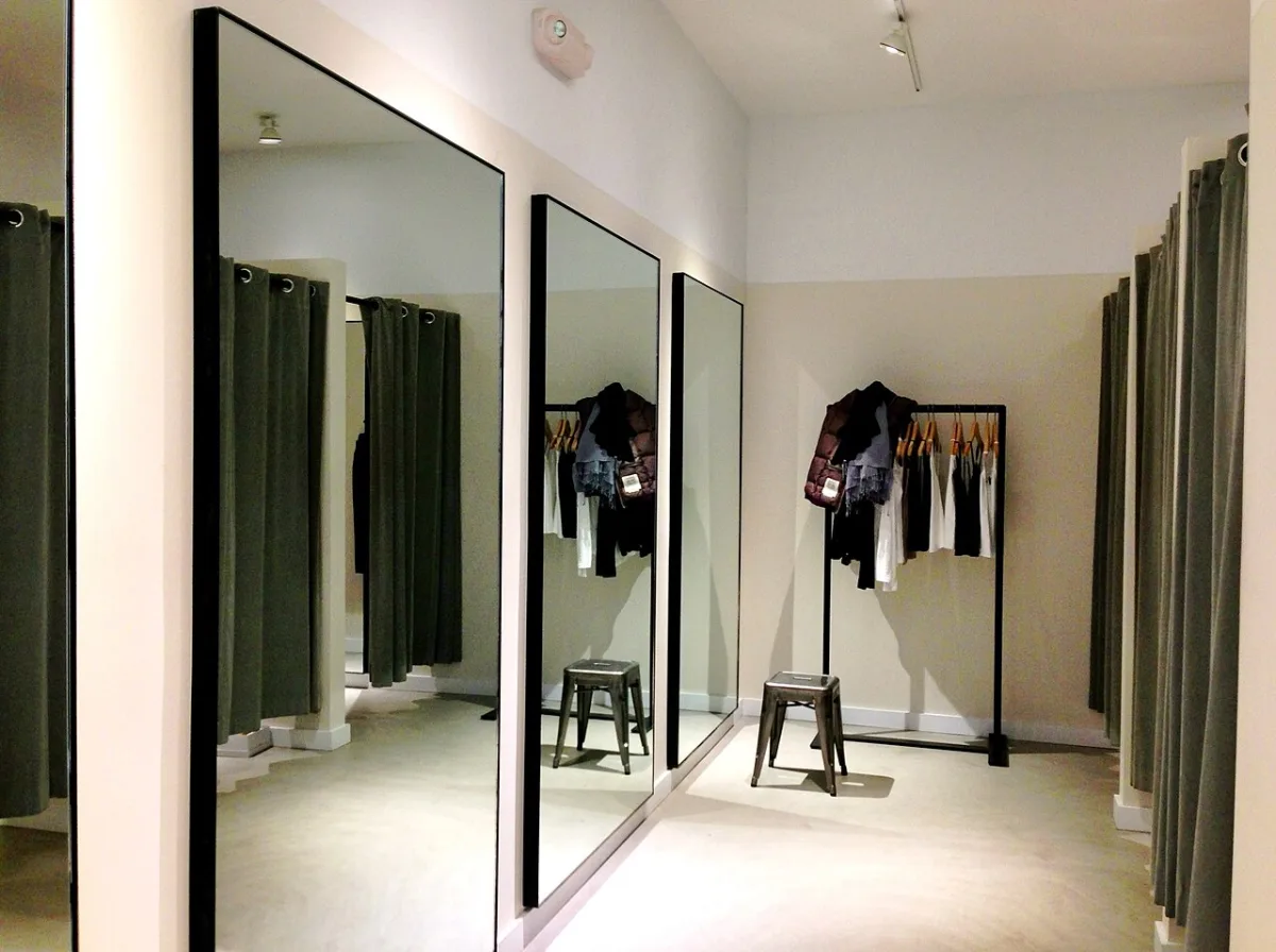 Rij paskamers met grote spiegels in een kledingwinkel